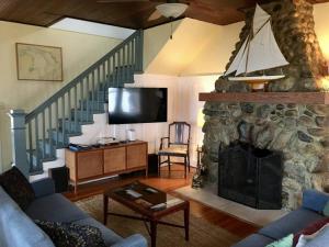 - un salon avec une cheminée en pierre et un escalier dans l'établissement Waterfront Cottages in Lexington Vacation Homes, à Lexington