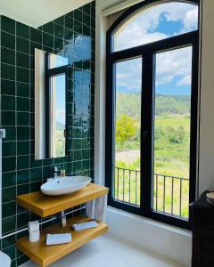 a bathroom with a sink and a window with a view at Quinta de Fiães in Vilar de Maçada