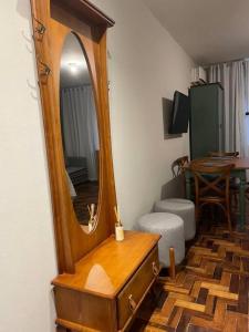a wooden dresser with a mirror on top of it at Loft aconchegante no Menino Deus in Porto Alegre