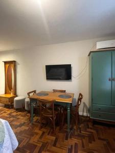 a room with a table and chairs and a tv at Loft aconchegante no Menino Deus in Porto Alegre