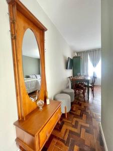 a living room with a mirror on a dresser at Loft aconchegante no Menino Deus in Porto Alegre