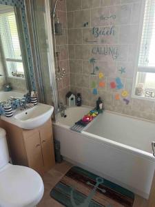 een badkamer met een bad, een wastafel en een toilet bij Large 2 Bedroom cabin Stunning Views on an 18 Hole golf course in Tydd Saint Giles
