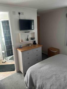 een slaapkamer met een bed en een televisie aan de muur bij Large 2 Bedroom cabin Stunning Views on an 18 Hole golf course in Tydd Saint Giles