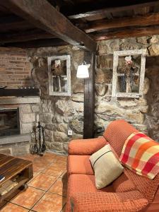a living room with a couch and a stone wall at La Saleta in Bejes
