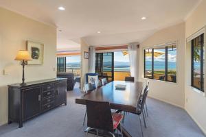 a living room with a dining room table and chairs at Jacaranda - Views over Tasman Bay in Nelson
