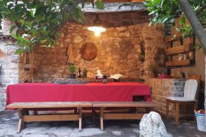 a table with a red table cloth and a bench at Holiday Home Fisherman's in Petrovac na Moru