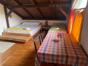 a bedroom with a bed and a table with flowers on it at Holiday Home Fisherman's in Petrovac na Moru