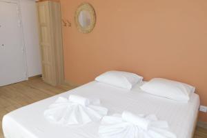 un letto bianco con cuscini bianchi sopra di Cosy air-conditioned T1 "Regency" a Antibes