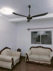 2 weiße Sofas im Wohnzimmer mit Deckenventilator in der Unterkunft Descansa sin Ruidos Departamento Limón in Tuxtla Gutiérrez