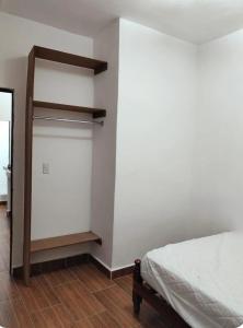 ein Schlafzimmer mit einem Schrank mit einem Bett und einem Spiegel in der Unterkunft Descansa sin Ruidos Departamento Limón in Tuxtla Gutiérrez