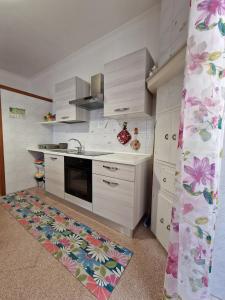 uma cozinha com armários brancos e um tapete de cozinha em CIVICO 26 em Bisceglie
