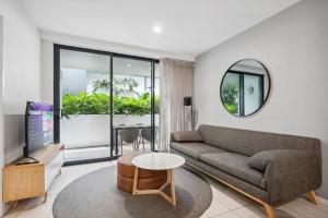 a living room with a couch and a table at Boutique 1 Bedroom Apartment, Central location in Brisbane