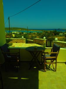 stół i krzesła na balkonie z widokiem na ocean w obiekcie Anemoni w mieście Diakofti