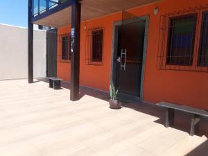 een gebouw met een oranje muur met een deur en een plant bij Pousada Paraiso Guarapari in Guarapari
