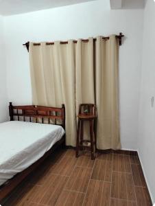 Schlafzimmer mit einem Bett, einem Tisch und Vorhängen in der Unterkunft Descansa sin Ruidos Departamento Limón in Tuxtla Gutiérrez