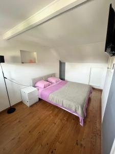 a bedroom with a bed with pink pillows at Maison avec beau jardin in Pierrelaye