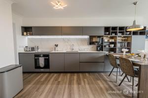 a kitchen with a table and a dining room at Shoreline Suite by Grandeur Property in Southbourne