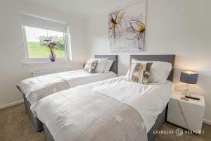 two beds in a bedroom with a window at Shoreline Suite by Grandeur Property in Southbourne