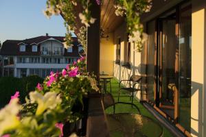 uma varanda com mesa, cadeiras e flores em Villa Andalucia SPA & Leisure em Ciechocinek