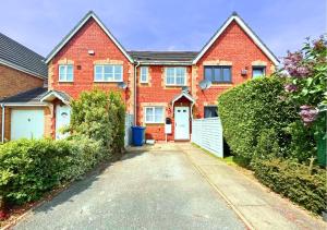 a red brick house with a driveway at Central Peaceful Home with Parking, Wi-Fi and Garden in Stafford