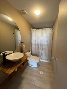 a bathroom with a sink and a toilet and a mirror at Casa Andes in San Pedro de Atacama