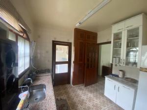 une cuisine avec un évier et une porte dans une pièce dans l'établissement LOURENCO & ELISABETHY, à Guarujá 12 autres photos