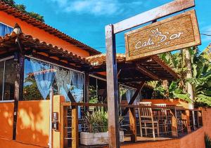 een restaurant met een bord aan de voorzijde bij Calador Búzios Hotel in Búzios