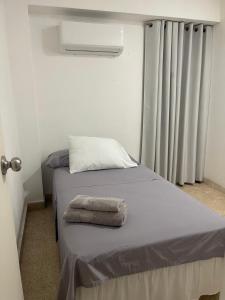 a bed with a towel on it in a room at Habitaciones privadas en un departamento encantador in Panama City