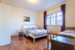 1 Schlafzimmer mit 2 Betten und einem Fenster in der Unterkunft Apartments with a parking space Vinisce, Trogir - 1165 in Vinišće