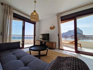 Una sala de estar con un sofá y vista al mar. en Apartamento Dúplex Aloha Calpe, primera línea de playa, en Calpe 28 fotos más