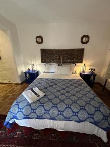 a bedroom with a blue and white bed with two tables at NuriahBoutique in Boliqueime