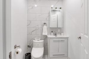 a white bathroom with a toilet and a sink at Montreal's most incredible apart in Montreal