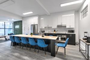 a kitchen with a large island with blue chairs at Montreal's most incredible apart in Montreal