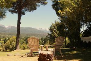 エル・ボルソンにあるCabañas Cerro Amigoの椅子2脚、テーブル1脚、木切り株