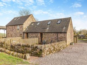 una casa de piedra con una pared de piedra y una valla en Jacobs Barn - Uk46733, en Wootton