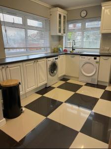 a kitchen with a washing machine and a checkered floor at London Guest Room in London