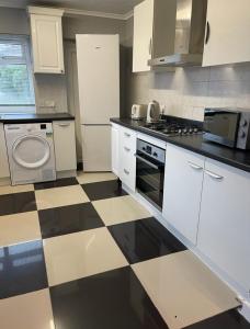 a kitchen with a black and white checkered floor at London Guest Room in London