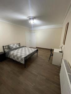 倫敦的住宿－倫敦客房旅館，铺有木地板的客房内设有一间卧室和一张床。