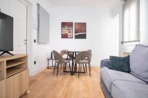 a living room with a table and chairs and a couch at Alojamientos con encanto a orillas del Manzanares in Madrid