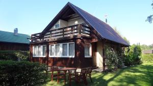 Una pequeña casa de madera con una mesa delante de ella. en Dom Wakacyjny, en Rowy