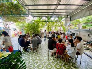 a group of people sitting at tables in a restaurant at Kh&aacute;ch Sạn Hiệp Sĩ L&yacute; Sơn in Ly Son