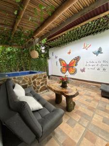 a living room with a couch and a butterfly wall at La cabaña in Pereira