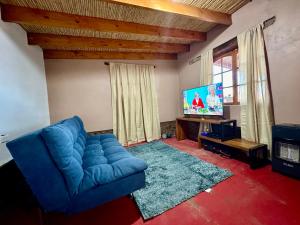 a living room with a blue couch and a tv at casa turis in San Pedro de Atacama