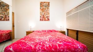 a bedroom with a large red bed and two windows at Are Kapakapa in Arutanga