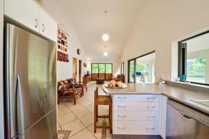 a kitchen with a refrigerator and a living room at Are Kapakapa in Arutanga