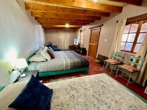 1 dormitorio con 2 camas, mesa y sillas en casa turis en San Pedro de Atacama