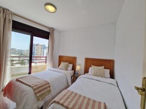 Cama o camas de una habitación en Apartamento Dúplex Aloha Calpe, primera línea de playa