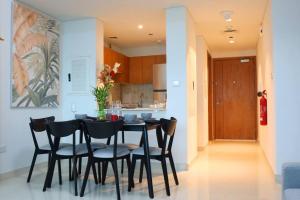 a kitchen and dining room with a table and chairs at Al Reem Cozy 1BR Apartment - Comfortable Stay Near Reem Mall & Al Maryah Island in Abu Dhabi