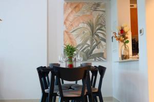 a dining room table with chairs and a vase of flowers at Al Reem Cozy 1BR Apartment - Comfortable Stay Near Reem Mall & Al Maryah Island in Abu Dhabi