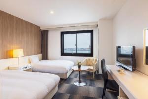 a hotel room with two beds and a television at City Hotel Air Port in Prince in Izumi-Sano +54 photos